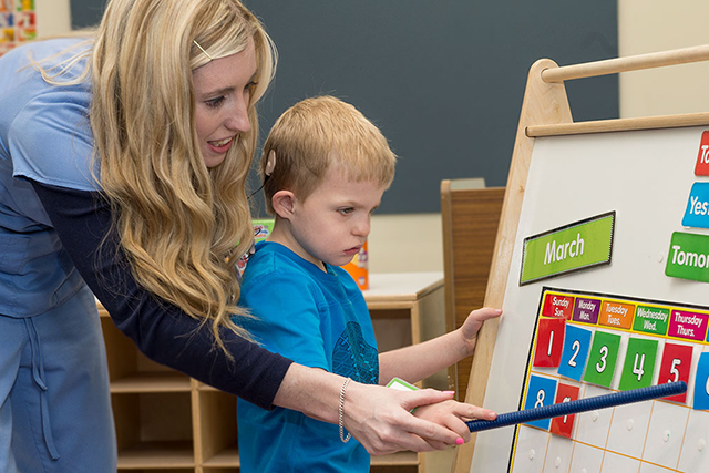 UNT faculty working with a child