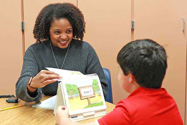 UNT graduate Elizabeth Atkins, and Educational Diagnostician with the Carrollton-Farmers Branch ISD, works with a students. 