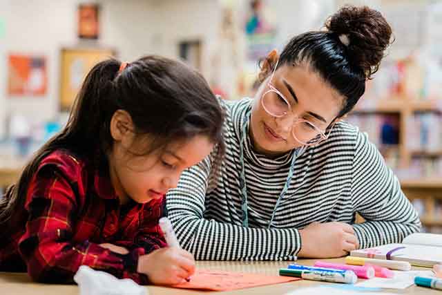 A student teacher works with a child at Ginnings Elementary School.