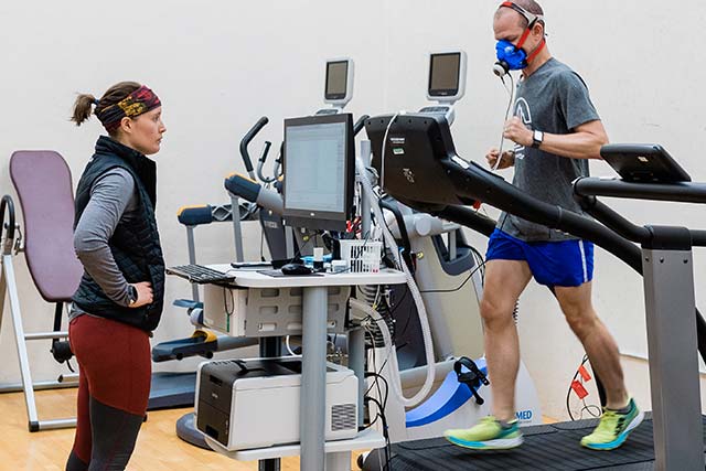 A faculty member runs on a treadmill while being observed