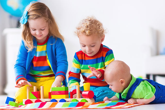 Children playing with colorful toys on a blanket