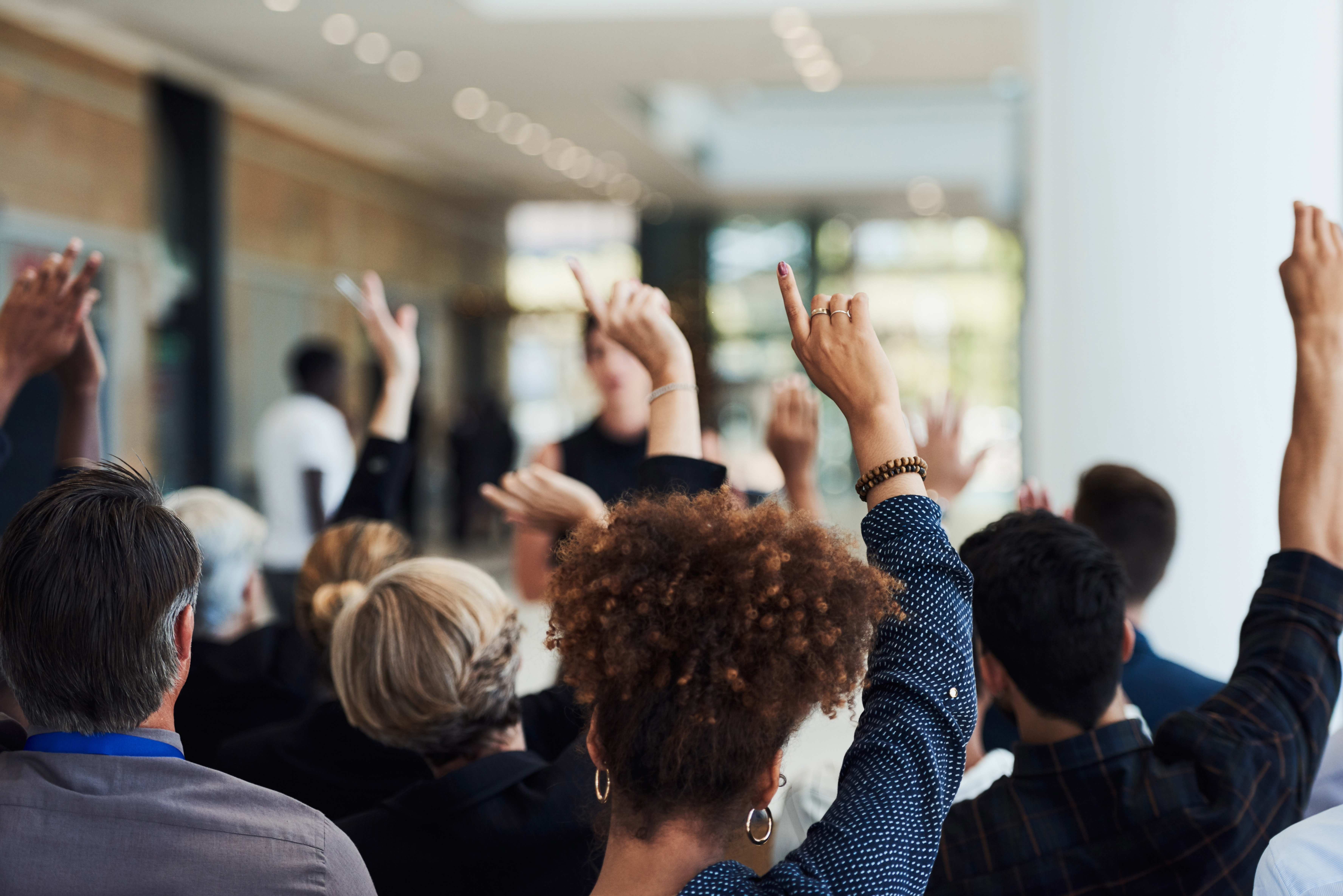 people raising their hands with questions