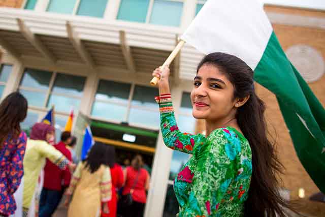 A UNT student carries and green and white flag for the flag parade, which featured flags from dozens of countries.