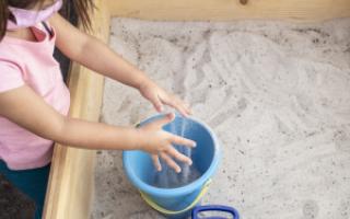 A child plays in a sandbox at the Center for Play Therapy's outdoor playroom