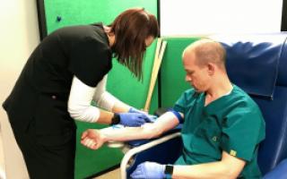 A graduate student draws blood from Dr. Brian McFarlin